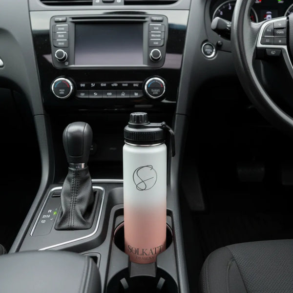 coral pink 650ml drink bottle sitting in a car cupholder - Solkatt Designs