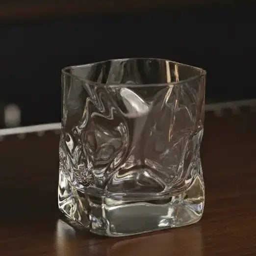 Crumple Japanese Whisky Glass on a bar top, showcasing its unique crumpled texture and elegant design.