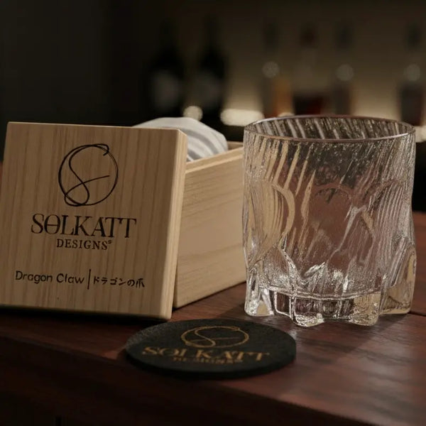Dragon Claw whisky glass displayed next to a wooden gift box on a bar, perfect for gifting.