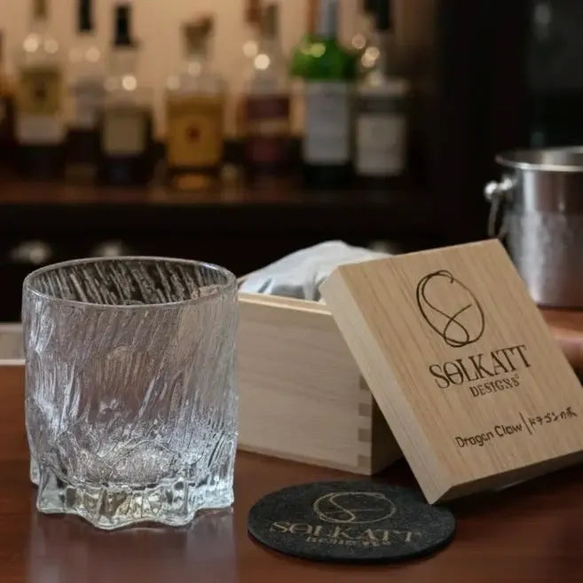 Close-up of Dragon Claw whisky glass with coaster and gift box, showcasing crystal detailing.