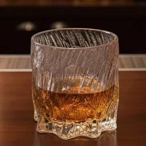 Dragon Claw whisky glass reflecting bar light, emphasizing its crystal clarity and claw design.