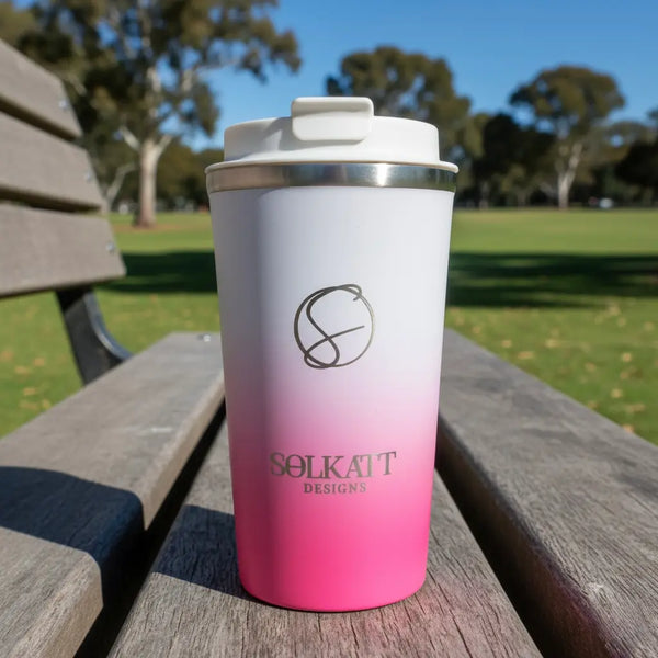 Hot pink stainless steel travel mug in an Australian park — reusable coffee cup designed for rugged adventures.