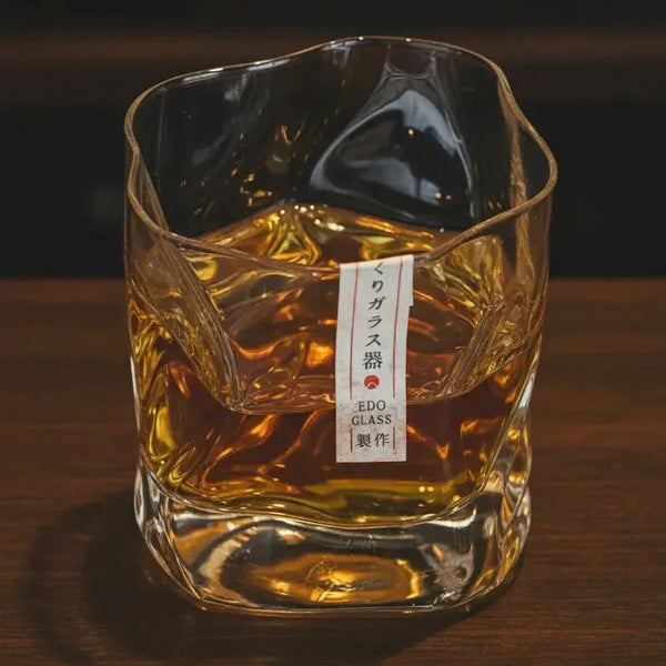 Crumple Whisky Glass filled with golden bourbon, showing the glow through the crumpled surface.