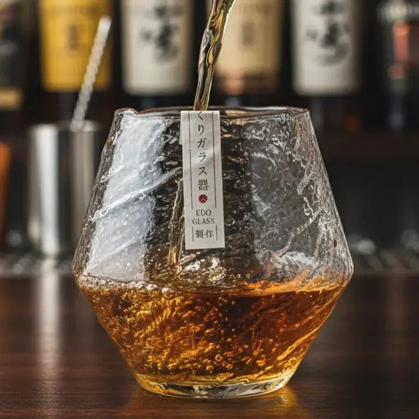 Whisky being poured into a Japanese snowflake style whisky glass on a bar.