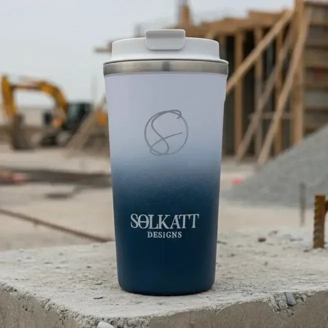 Royal blue stainless steel travel mug on construction site — reusable coffee cup perfect for outdoor breaks.