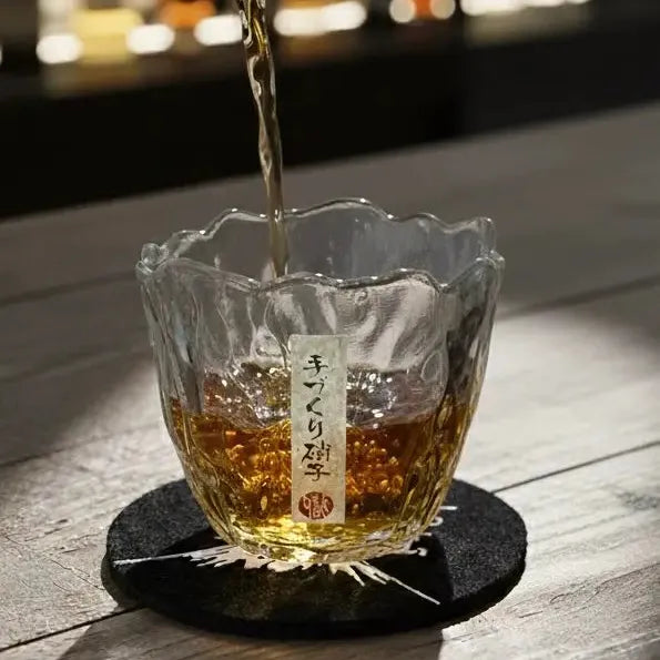 Japanese whisky glass with golden whisky being poured into it on a bar.