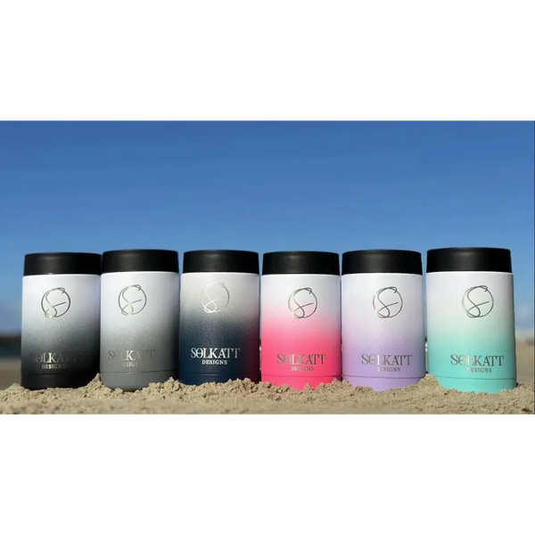 All six stainless steel insulated stubby coolers on the beach – Hot Pink, Lavender Lilac, Royal Blue, Misty Grey, Ocean Aqua, Midnight Black – Solkatt Designs