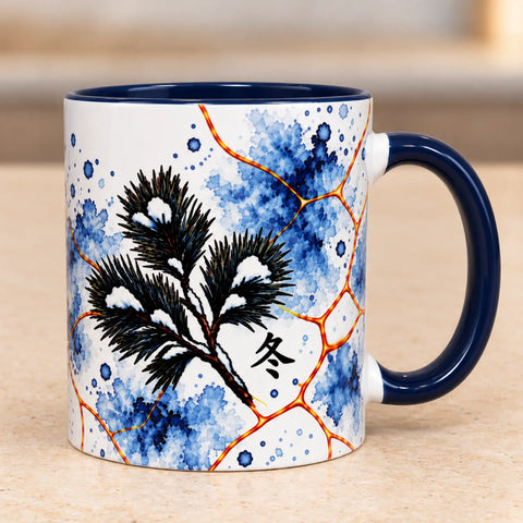 Left side of Winter ceramic coffee mug showing snow-covered pine branches against blue watercolour artwork with glossy navy blue handle.